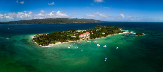 Fototapeta na wymiar Aerial drone panorama view of the paradise island with white sand beach, blue water, resort hotel and boats around, Cayo Levantado, Dominicana