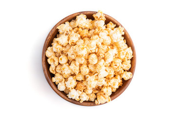 Popcorn with caramel in wooden bowl isolated on white background. Top view.