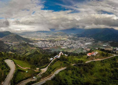 Aerial drone view of Jesus baby statue (Divino Ni&ntilde;o), mountains and valley with city Constanza, Dominican Republic 