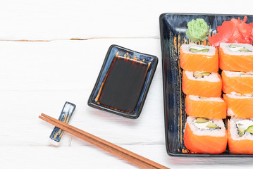 Sushi rolls and soy sauce on the white background.
