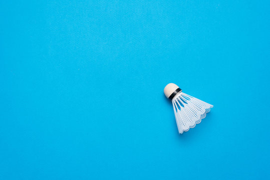 A white shuttlecock on the blue background.
