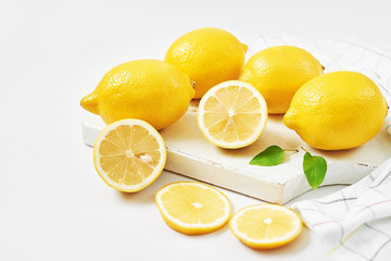 Lemons background. Group of lemons with leaves on white background. Citruses and vitamins. Creative layout made of lemon and leaves. Flat lay. Food concept. Vegetarianism and veganism. Summer