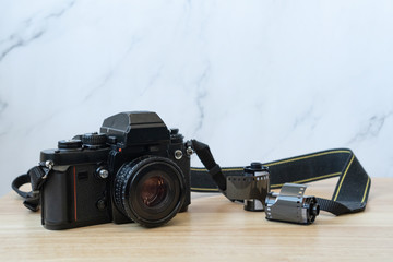 camara vintage negra junto rollos de film sobre madera