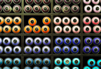 Painted spray paint canisters on shelf, multicolored graffiti cans. Paint dispenser, spray bottles,...