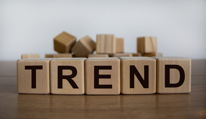 Concept word 'trend' on cubes on a beautiful wooden table. White background. Business concept.