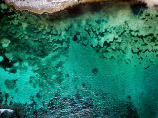 Aerial drone view of transparent water of Caribbean Sea and coral reef floor at the bottom near Saona Island, Dominican Republic 