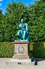 Obraz premium Statue of the Danish writer Hans Christian Andersen in the park of Rosenborg Castle, Copenhagen, Denmark, built in the Dutch Renaissance style in the 17th century.