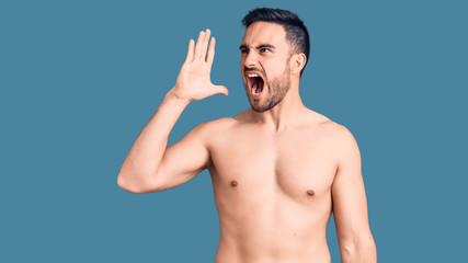 Fototapeta premium Young handsome man wearing swimwear shouting and screaming loud to side with hand on mouth. communication concept.