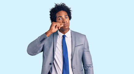 Handsome african american man with afro hair wearing business jacket mouth and lips shut as zip...