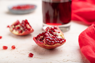 Glass of pomegranate juice on a white concrete background. Side view, selective focus