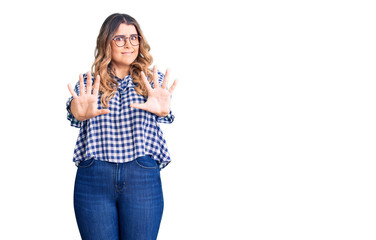 Young caucasian woman wearing casual clothes afraid and terrified with fear expression stop gesture with hands, shouting in shock. panic concept.
