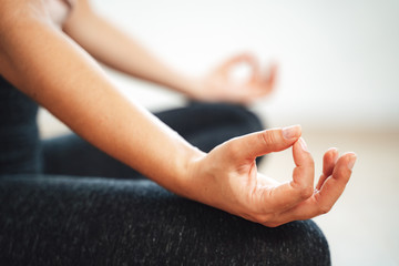 Close up hand of young female pose and practice meditation in lotus position at home