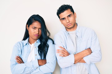Beautiful latin young couple wearing casual clothes skeptic and nervous, disapproving expression on...