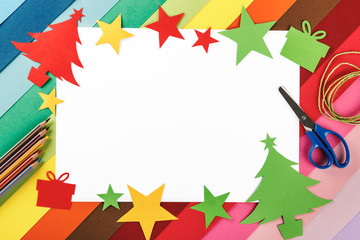 Fototapeta na wymiar Frame of Christmas trees and decorations made of cardboard and material for making crafts on a background of many colors. Top view. Homemade. Crafts for Christmas. Copy space for text or image.