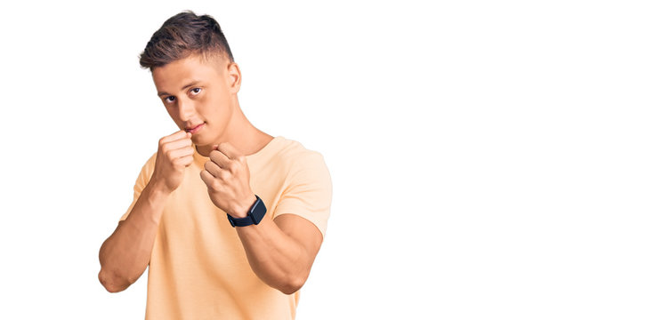 Young handsome man wearing casual clothes ready to fight with fist defense gesture, angry and upset face, afraid of problem