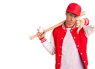 Young handsome man playing baseball holding bat and ball with angry face, negative sign showing dislike with thumbs down, rejection concept