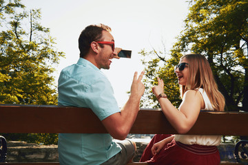 Naklejka premium Couple in love using cellphone outdoors.