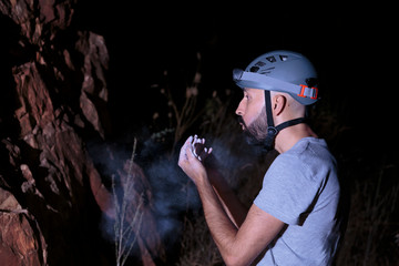 Hispanic male climber blowing chalk off his hands