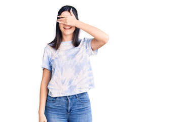 Fototapeta premium Young beautiful girl wearing casual t shirt smiling and laughing with hand on face covering eyes for surprise. blind concept.