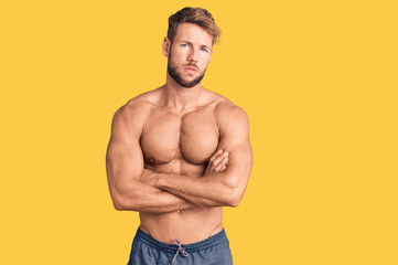 Fototapeta premium Young caucasian man standing shirtless skeptic and nervous, disapproving expression on face with crossed arms. negative person.