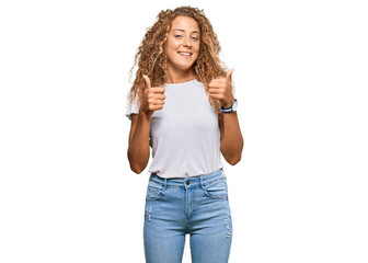 Fototapeta premium Beautiful caucasian teenager girl wearing casual white tshirt success sign doing positive gesture with hand, thumbs up smiling and happy. cheerful expression and winner gesture.