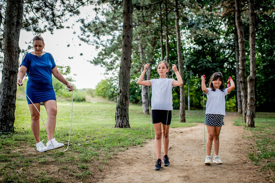 School children in white t shirts skipping ropes at public park