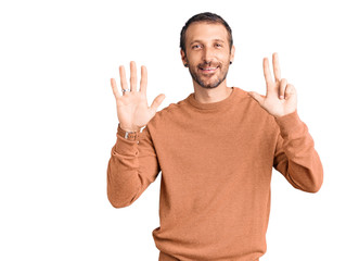 Young handsome man wearing casual clothes showing and pointing up with fingers number eight while smiling confident and happy.