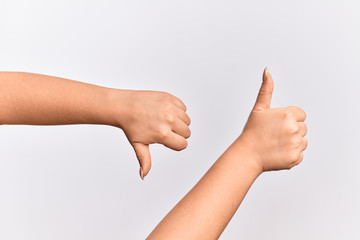 Hand of caucasian young woman showing disagree and agreement with thumbs up and thumbs dow, mixed emotions idea