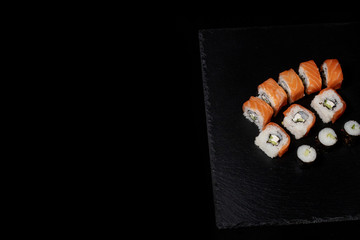 Philadelphia roll with salmon, cheese and cucumber on a black background. Sushi Philadelphia