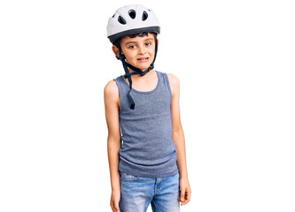 Little cute boy kid wearing bike helmet looking positive and happy standing and smiling with a confident smile showing teeth