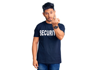 Handsome latin american young man wearing security t shirt showing middle finger, impolite and rude fuck off expression