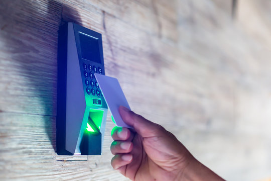 Door access control. Staff holding a key card to lock and unlock door at home or condominium. Using electronic card key for access. Electronic key and finger scan access control system to unlock doors