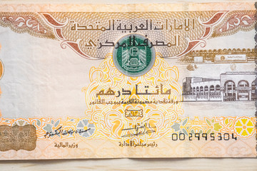 Closeup of UAE 200 dirhams currency notes on light wooden table from high angle, paper money