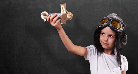 little cute girl with airplane and pilot glasses in hand. back to school concept.