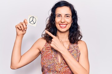 Naklejka premium Young beautiful hispanic woman holding peace symbol reminder paper smiling happy pointing with hand and finger