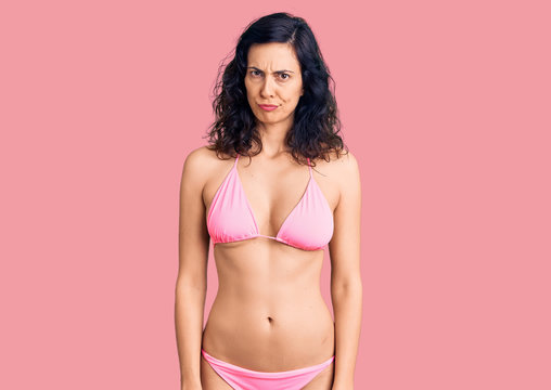 Young beautiful hispanic woman wearing bikini skeptic and nervous, frowning upset because of problem. negative person.