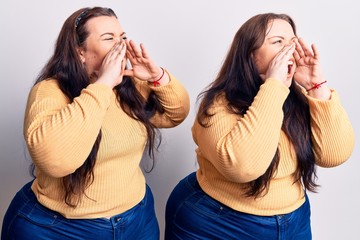 Young plus size twins wearing casual clothes shouting angry out loud with hands over mouth