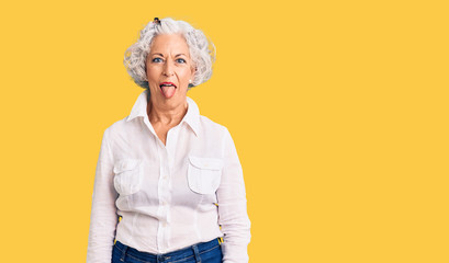 Senior grey-haired woman wearing casual clothes sticking tongue out happy with funny expression. emotion concept.