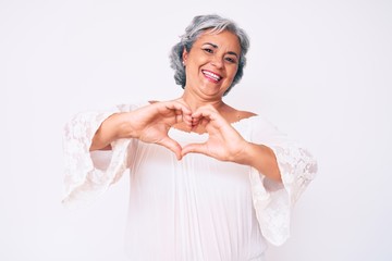 Senior hispanic grey- haired woman wearing casual clothes smiling in love doing heart symbol shape with hands. romantic concept.