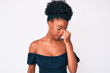 Fototapeta na wymiar Young african american woman wearing casual clothes tired rubbing nose and eyes feeling fatigue and headache. stress and frustration concept.