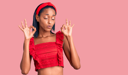 Young african american woman wearing casual summer clothes relax and smiling with eyes closed doing meditation gesture with fingers. yoga concept.