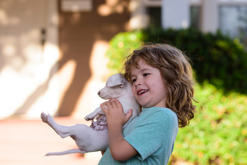 Funny photo of happy kid hugging beautiful puppy dog.
