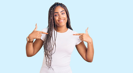 Young african american woman with braids wearing casual clothes looking confident with smile on face, pointing oneself with fingers proud and happy.