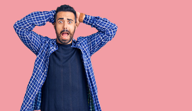 Young hispanic man wearing casual clothes crazy and scared with hands on head, afraid and surprised of shock with open mouth