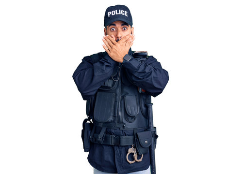 Young hispanic man wearing police uniform shocked covering mouth with hands for mistake. secret concept.