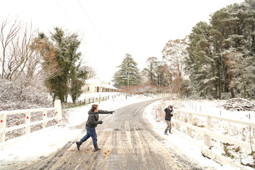 Boys having snow ball fight on bridge while it's snowing in Yetholme, New South Wales, Australia