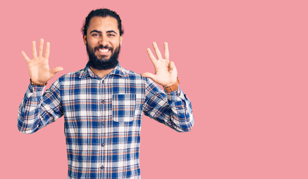 Young arab man wearing casual clothes showing and pointing up with fingers number nine while smiling confident and happy.