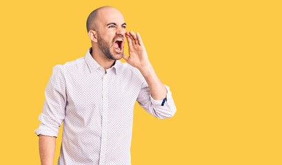 Young handsome man wearing elegant shirt shouting and screaming loud to side with hand on mouth. communication concept.