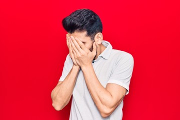 Young handsome man with beard wearing casual polo with sad expression covering face with hands while crying. depression concept.