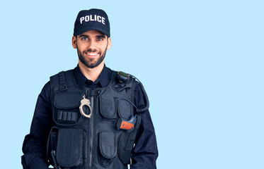 Young handsome man with beard wearing police uniform with a happy and cool smile on face. lucky person.